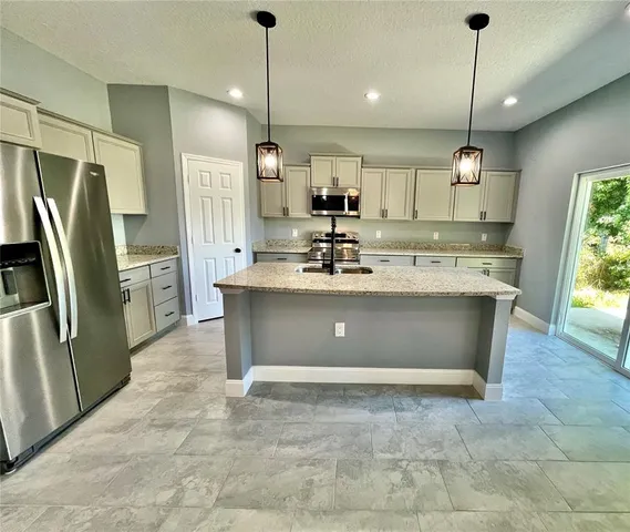 a kitchen with a refrigerator a sink and chandelier