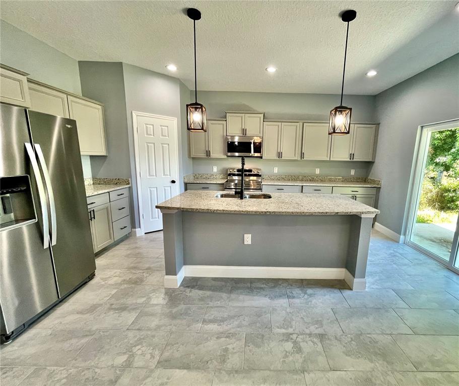 314 15th Avenue Ocoee, FL 34761 - Photo 23 of 37 a view of kitchen with stainless steel appliances granite countertop a stove a sink a refrigerator and a counter top space