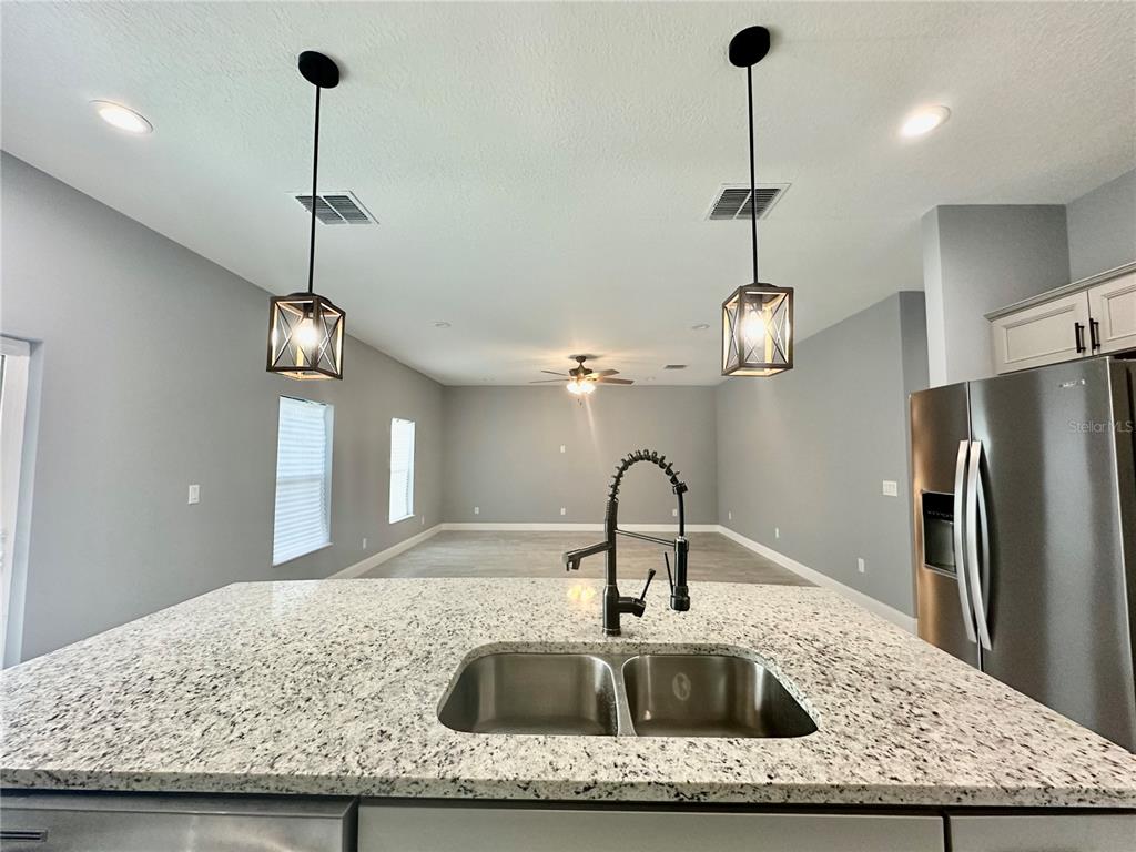 314 15th Avenue Ocoee, FL 34761 - Photo 24 of 37 a kitchen with a refrigerator a sink and chandelier