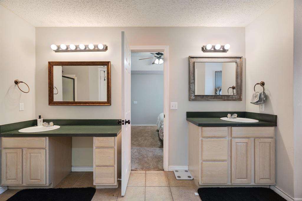 566 Turtle Creek Drive Reno, TX 75462 - Photo 11 of 19 Full bathroom with connected bathroom, two vanities, ceiling fan, a textured ceiling, and tile patterned floors