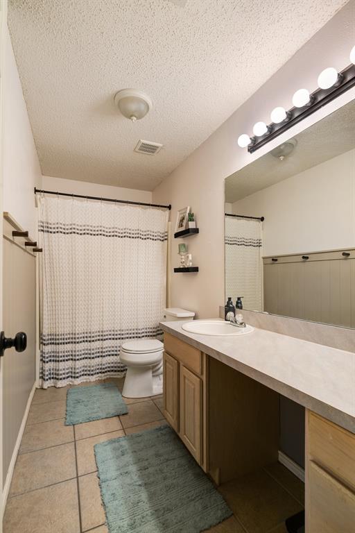 566 Turtle Creek Drive Reno, TX 75462 - Photo 14 of 19 Bathroom with vanity, tile patterned flooring, a textured ceiling, and a shower with shower curtain