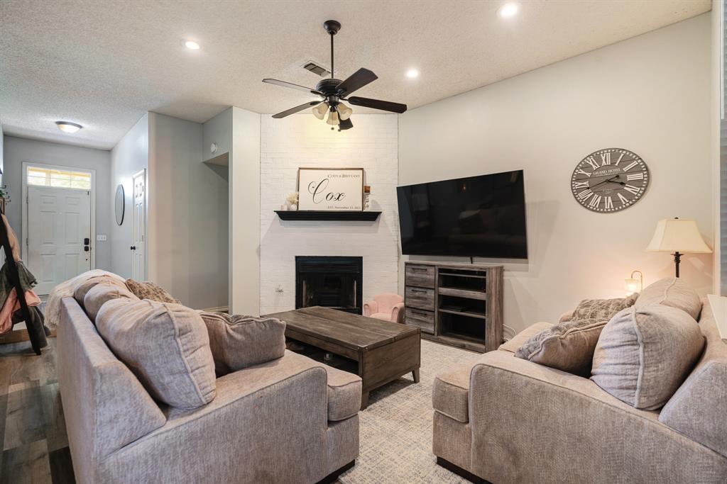 566 Turtle Creek Drive Reno, TX 75462 - Photo 3 of 19 Living area featuring a ceiling fan, a textured ceiling, a fireplace, recessed lighting, and wood finished floors
