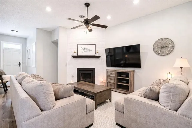 a living room with furniture a flat screen tv and a fireplace