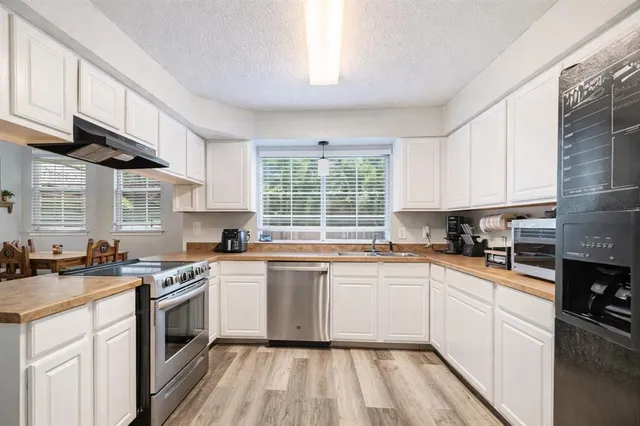 a kitchen with a white cabinets sink and white appliances