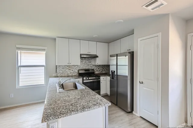 a kitchen with a refrigerator sink and stove