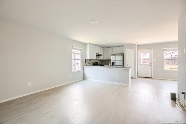 a view of kitchen with wooden floor and electronic appliances
