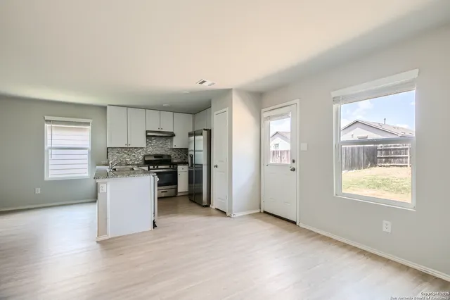 a kitchen with a refrigerator and white cabinets