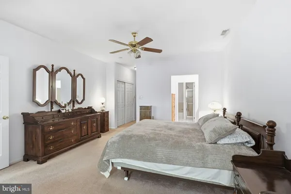 a bedroom with a bed and dresser with mirror