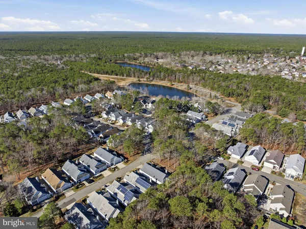 an aerial view of residential houses with outdoor space and trees