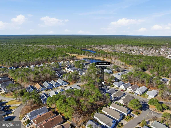an aerial view of residential houses with outdoor space and trees