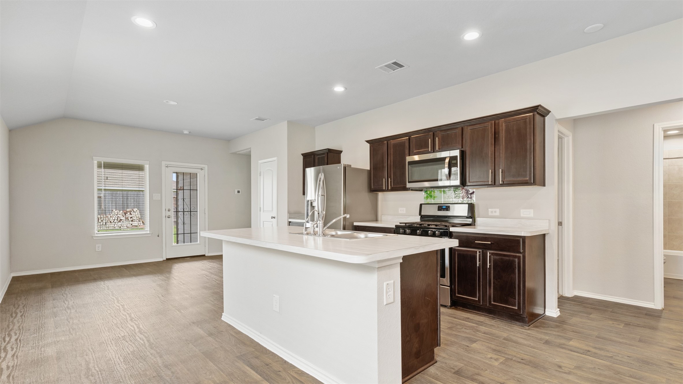 2311 Silver Plume Lane Spring, TX 77373 - Photo 7 of 24 a kitchen with stainless steel appliances granite countertop a stove top oven a sink dishwasher and a refrigerator with wooden floor