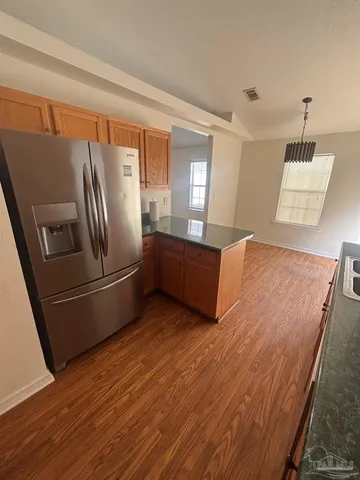 a kitchen with kitchen island a counter top space and stainless steel appliances wooden floor