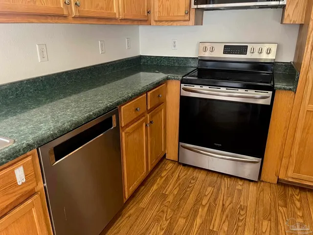 a kitchen with granite countertop a stove and a microwave