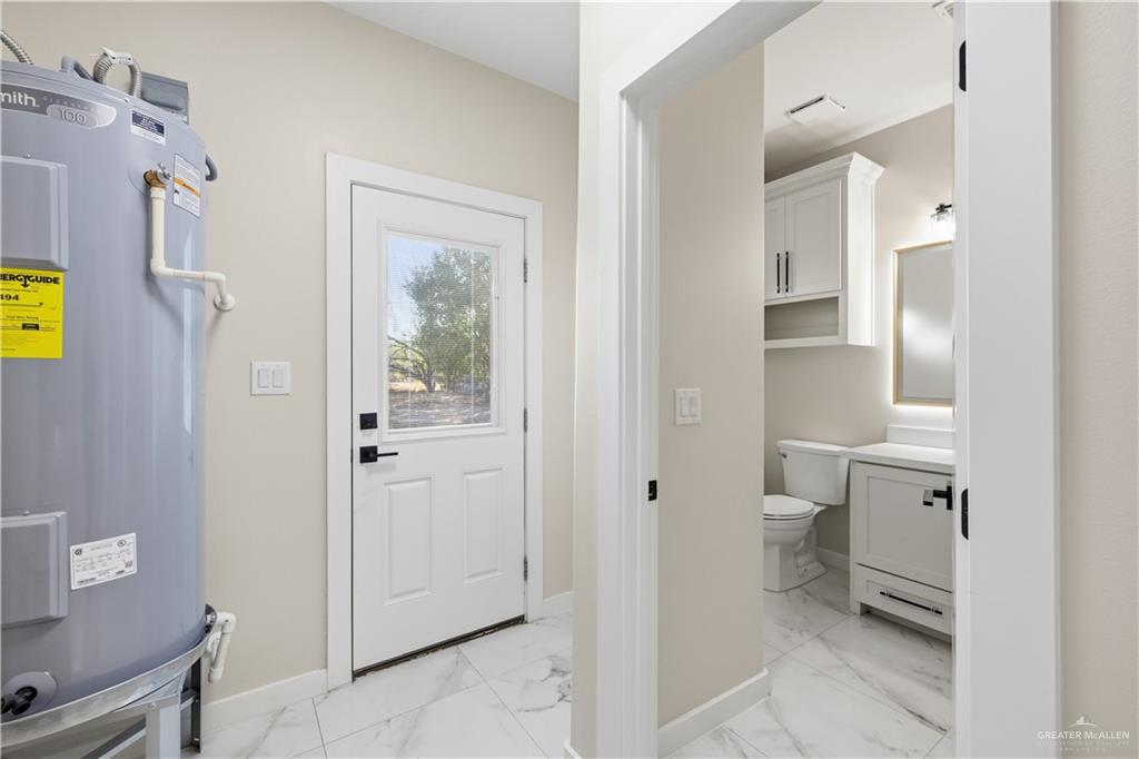 3509 Astrid Street Mission, TX 78574 - Photo 28 of 30 a bathroom with a granite countertop toilet and a shower