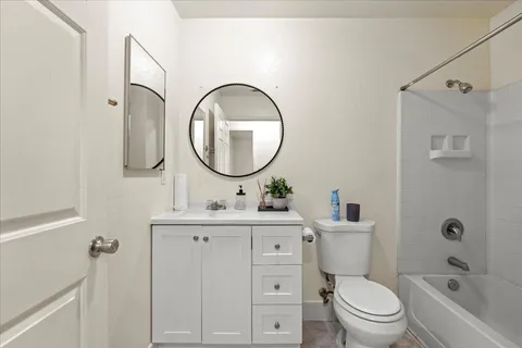 a bathroom with a toilet sink vanity tub and mirror