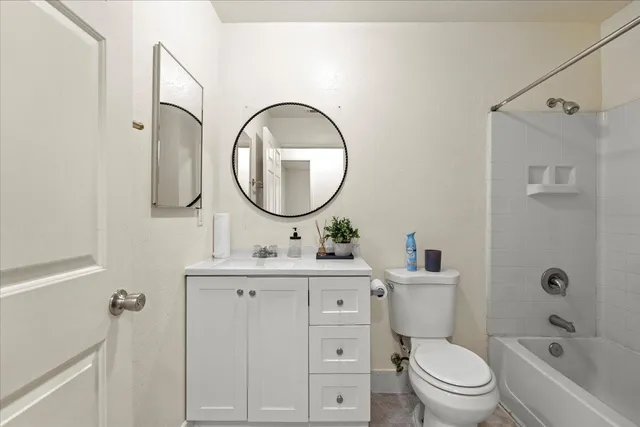 a bathroom with a toilet sink vanity tub and mirror