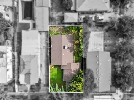 an aerial view of a residential houses with yard