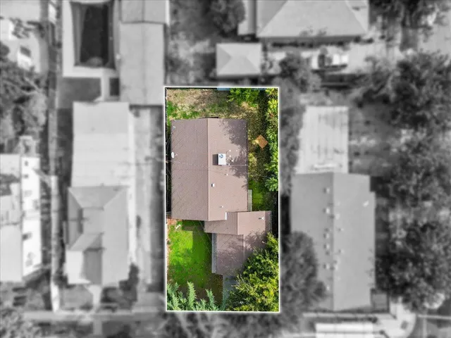 an aerial view of a residential houses with yard