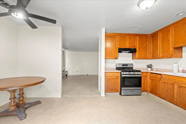 a kitchen with granite countertop a stove a sink and a refrigerator