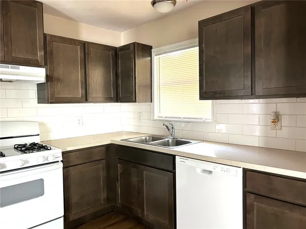 a kitchen with a sink stove and cabinets