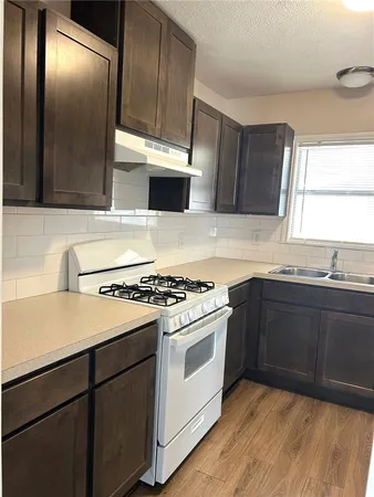 a kitchen with a stove sink and cabinets