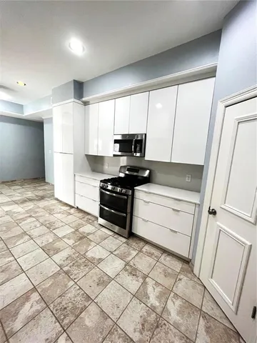 a kitchen with stainless steel appliances a refrigerator and a stove top oven