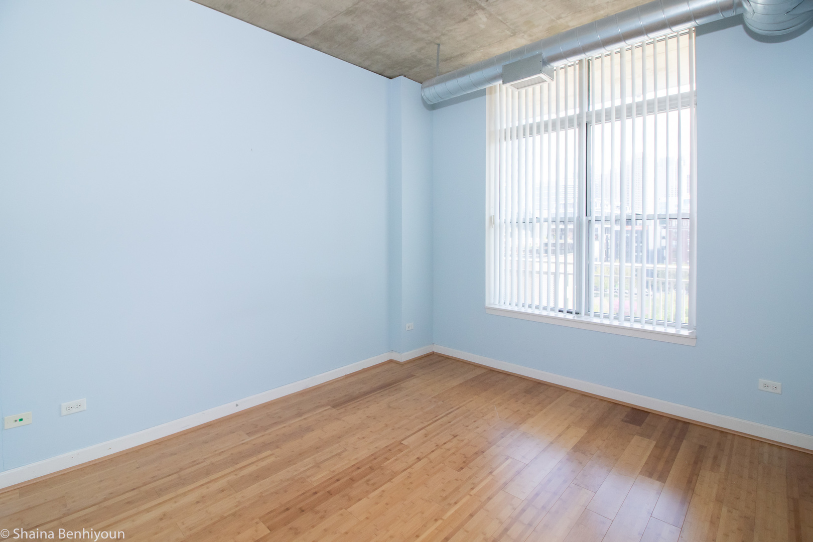 111 South Morgan Street, Unit 715 Chicago, IL 60607 - Photo 2 of 17 an empty room with wooden floor and windows