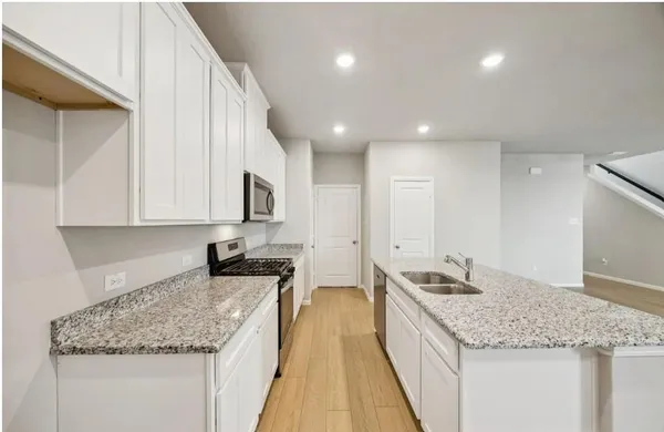 a kitchen with granite countertop sink stainless steel appliances and a counter top space