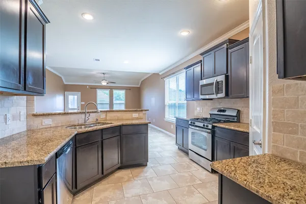 a kitchen with stainless steel appliances granite countertop a sink stove and refrigerator