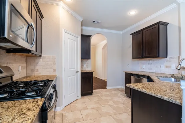 a bathroom with a granite countertop sink a mirror and cabinets