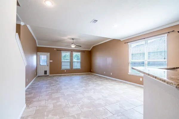 an empty room with windows and ceiling fan