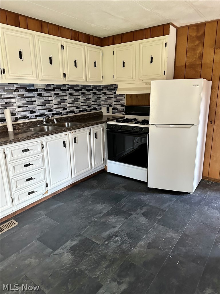 7443 Spillway Road Lisbon, OH 44432 - Photo 9 of 19 Kitchen featuring white appliances, dark tile flooring, custom range hood, and white cabinetry