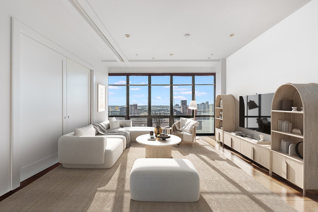 36 A Street, Unit 5D Boston, MA 02127 - Photo 2 of 13 a living room with furniture and large windows