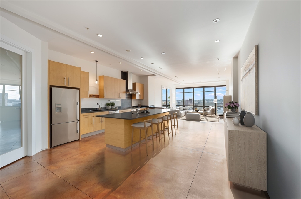 36 A Street, Unit 5D Boston, MA 02127 - Photo 3 of 13 a large open kitchen with a large window and stainless steel appliances