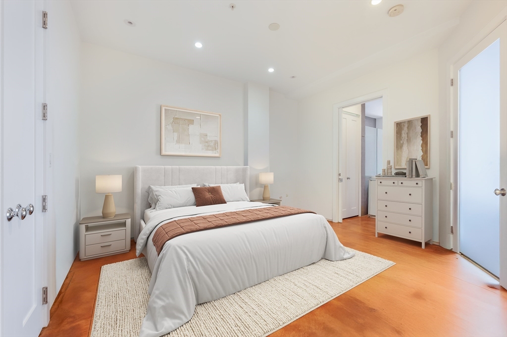 36 A Street, Unit 5D Boston, MA 02127 - Photo 4 of 13 a bedroom with a large bed and a chandelier