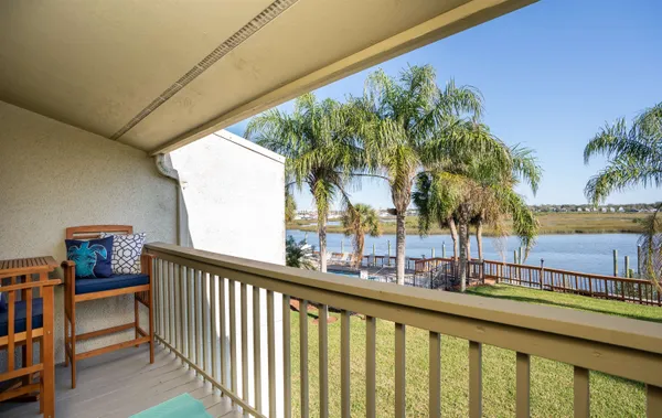 a view of balcony with two potted plants and palm trees