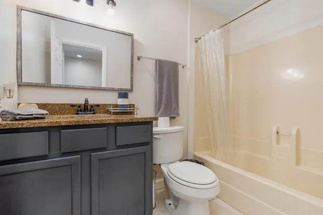 a bathroom with a granite countertop sink toilet and shower
