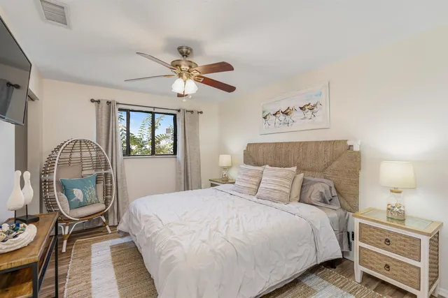a bedroom with a bed a chandelier and dresser