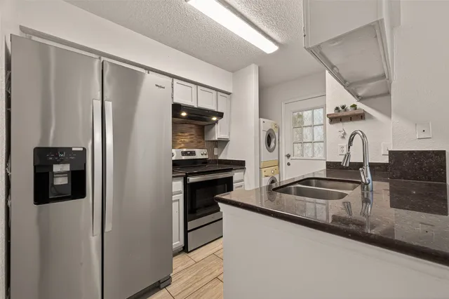a kitchen with stainless steel appliances granite countertop a refrigerator and a sink