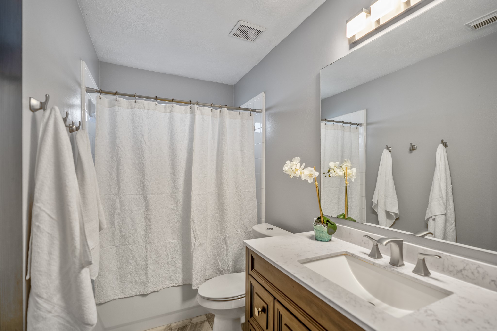 3411 Utah Beach Court Spring, TX 77388 - Photo 29 of 50 Near the secondary bedroom hall, the full bath offers a practical setup with bright vanity lighting and a tub/shower combination. Its central placement keeps the nearby bedrooms easy to serve while the wider vanity gives the space added function for daily routines.