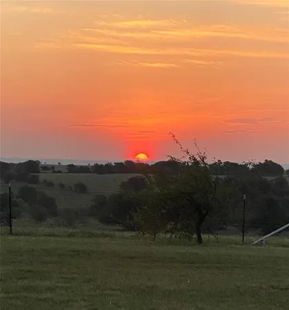 a view of mountain with sunset in background