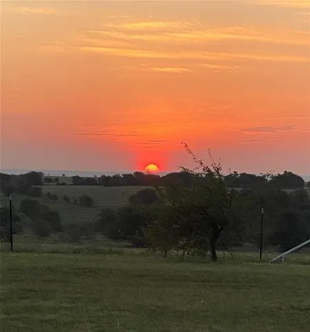 a view of mountain with sunset in background