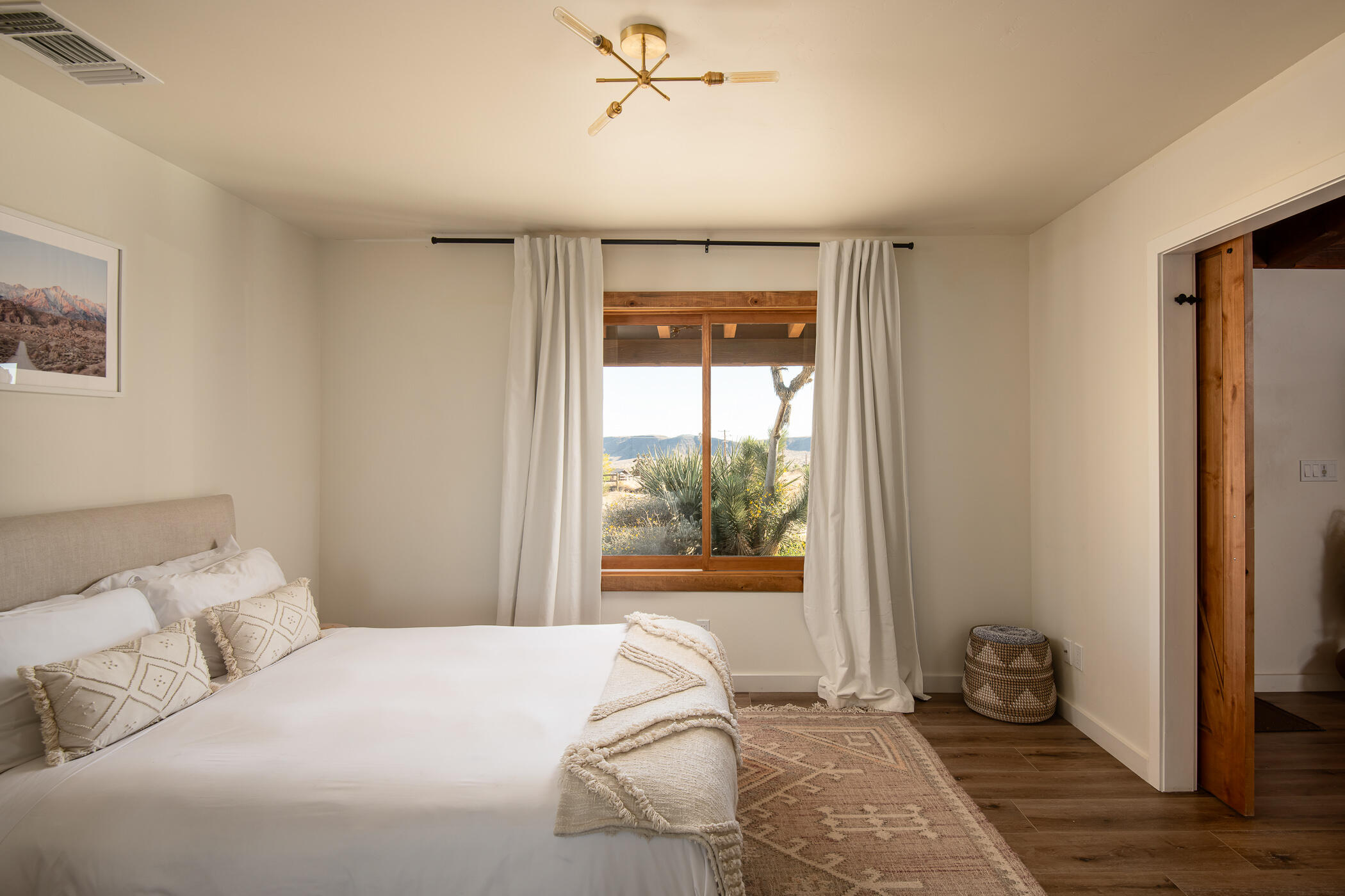 5544 Roy Rogers Road Pioneertown, CA 92268 - Photo 20 of 35 a bedroom with a bed and wooden floor