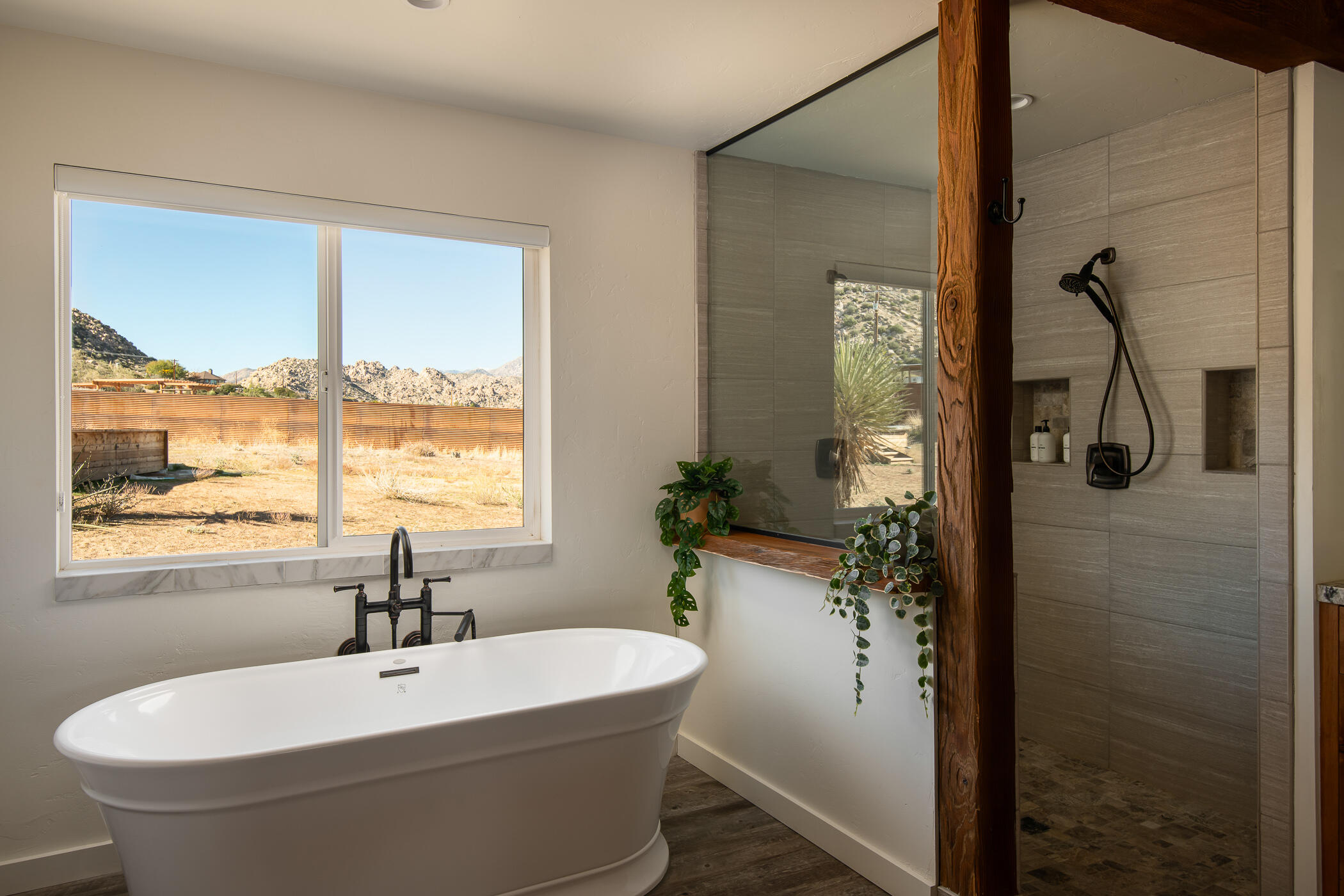 5544 Roy Rogers Road Pioneertown, CA 92268 - Photo 28 of 35 a bathroom with a white bath tub sitting next to a window