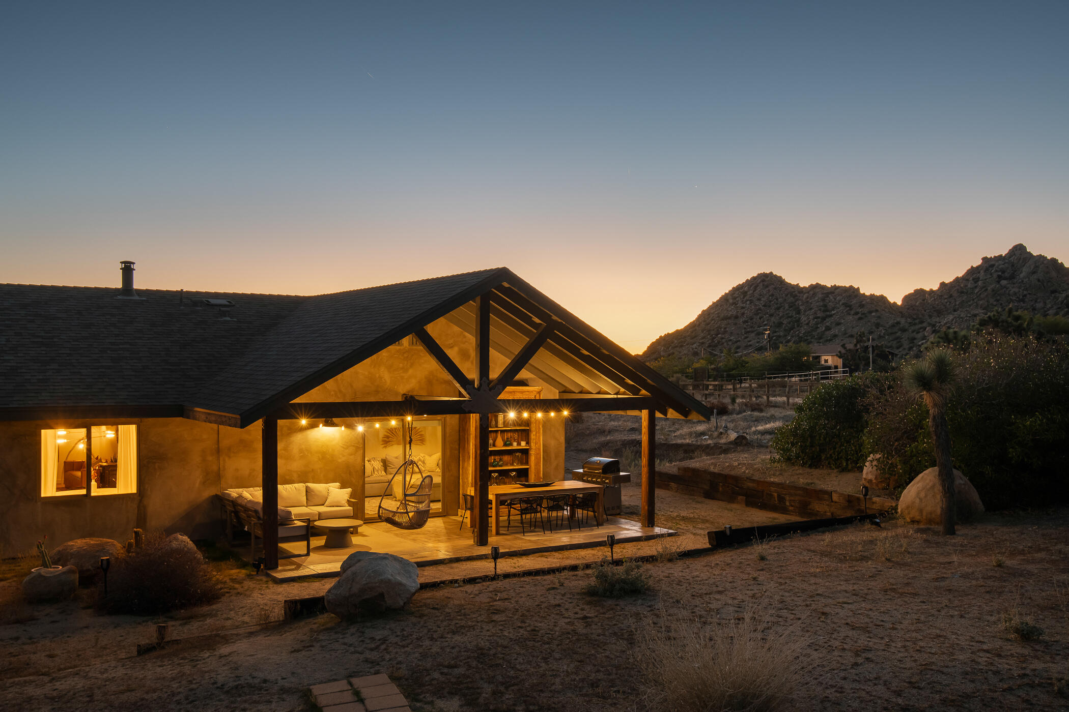 5544 Roy Rogers Road Pioneertown, CA 92268 - Photo 32 of 35 a view of a house with large windows and a yard