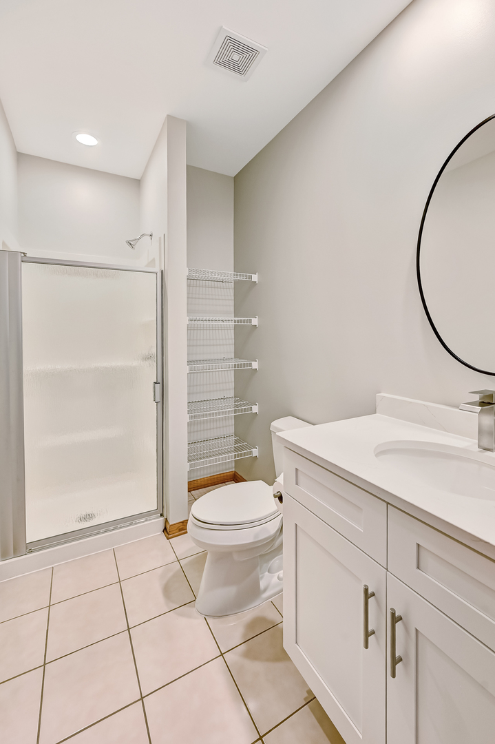 1938 Manning Road Darien, IL 60561 - Photo 11 of 23 a bathroom with a granite countertop sink toilet and shower