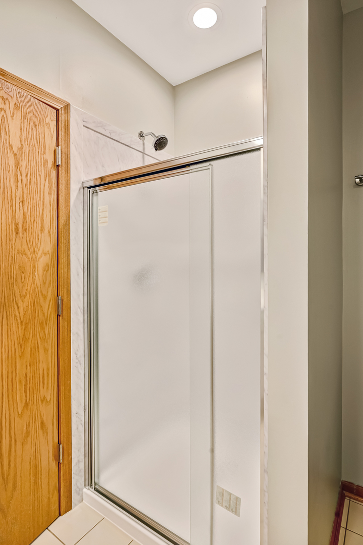 1938 Manning Road Darien, IL 60561 - Photo 15 of 23 a bathroom with a glass shower door