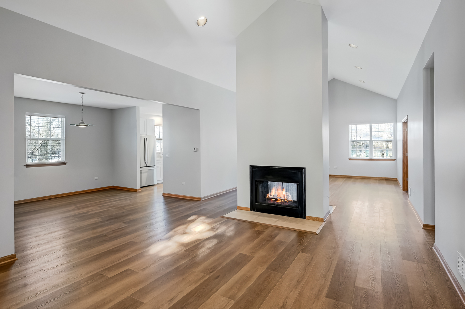 1938 Manning Road Darien, IL 60561 - Photo 4 of 23 an empty room with wooden floor a fireplace and windows