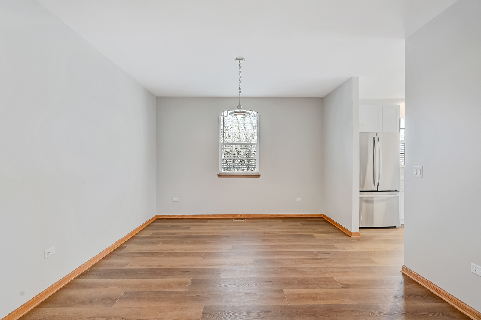 1938 Manning Road Darien, IL 60561 - Photo 5 of 23 a view of an empty room with wooden floor and a window