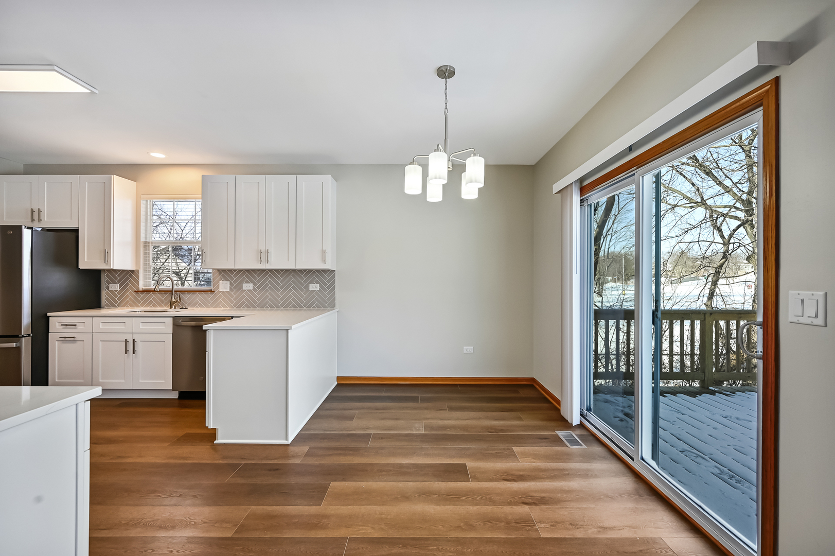 1938 Manning Road Darien, IL 60561 - Photo 9 of 23 a kitchen with white cabinets and wooden floor